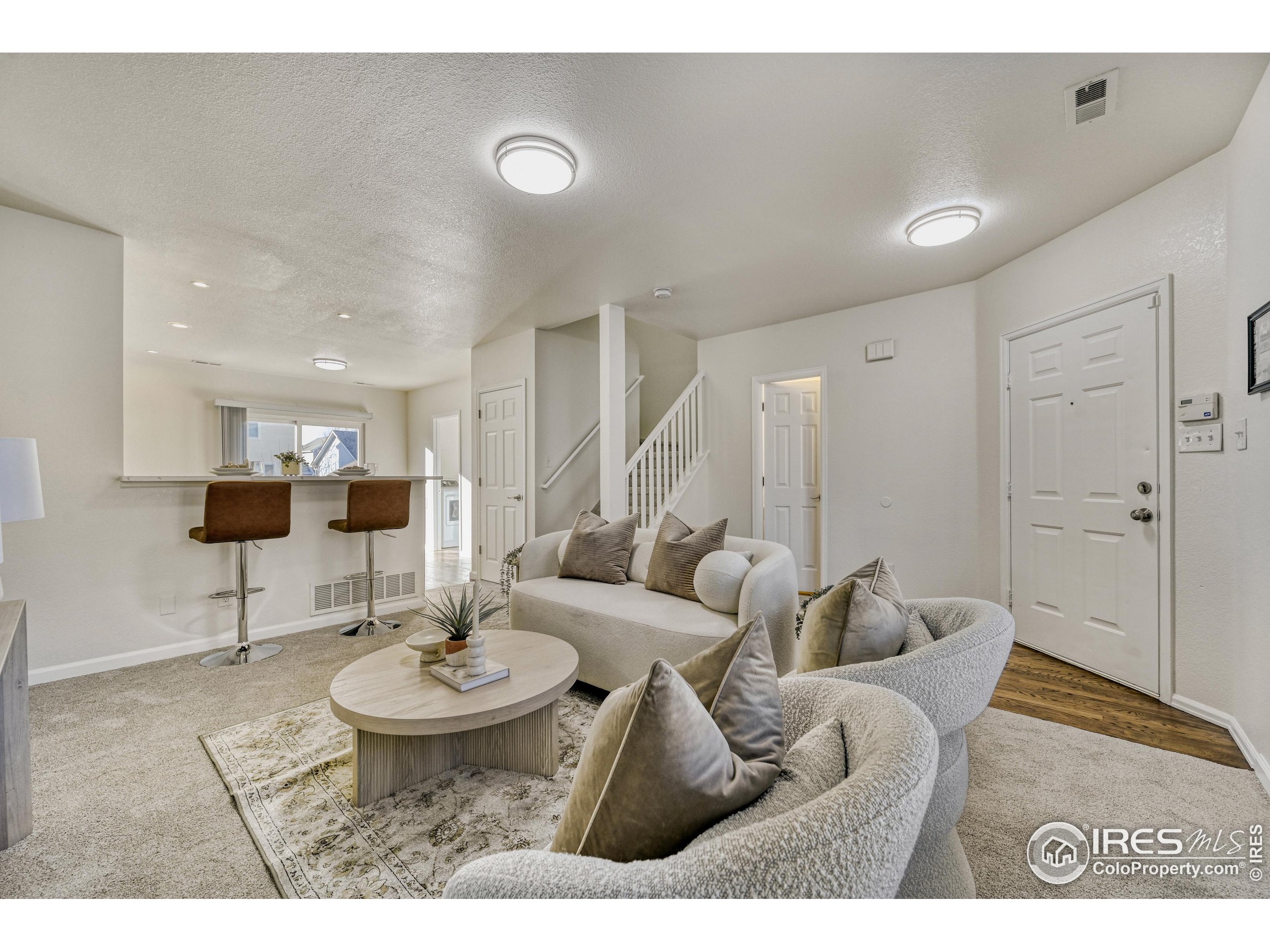 6130 Gorham Street Frederick, CO 80530 - Photo 5 of 48 a living room with furniture a rug and kitchen view