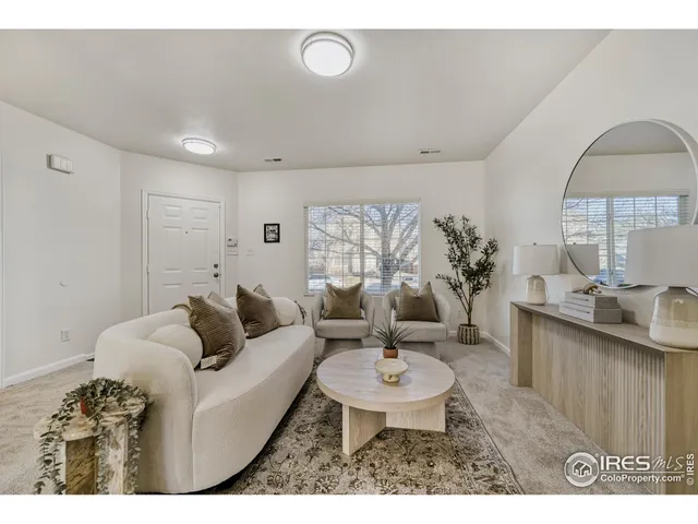 a living room with furniture a table and a potted plant