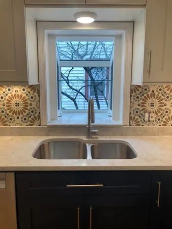 a view closed with granite countertop a sink a window and cabinets