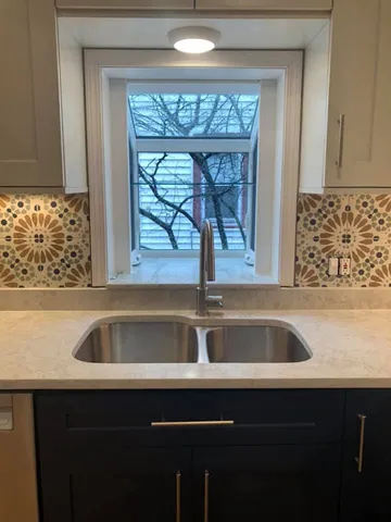 a view closed with granite countertop a sink a window and cabinets