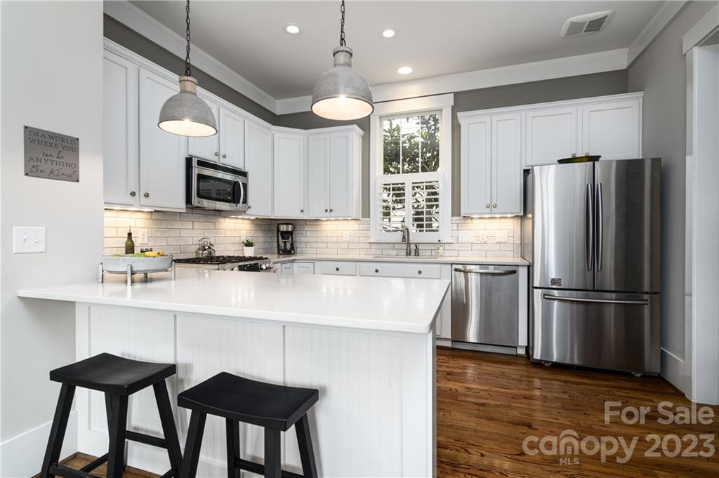 205 Coneflower Place Fort Mill, SC 29708 - Photo 9 of 38 a kitchen with kitchen island white cabinets and stainless steel appliances