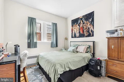 a bedroom with a bed and a painting on the wall