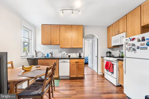 a kitchen with stainless steel appliances granite countertop a stove top oven a sink and a refrigerator