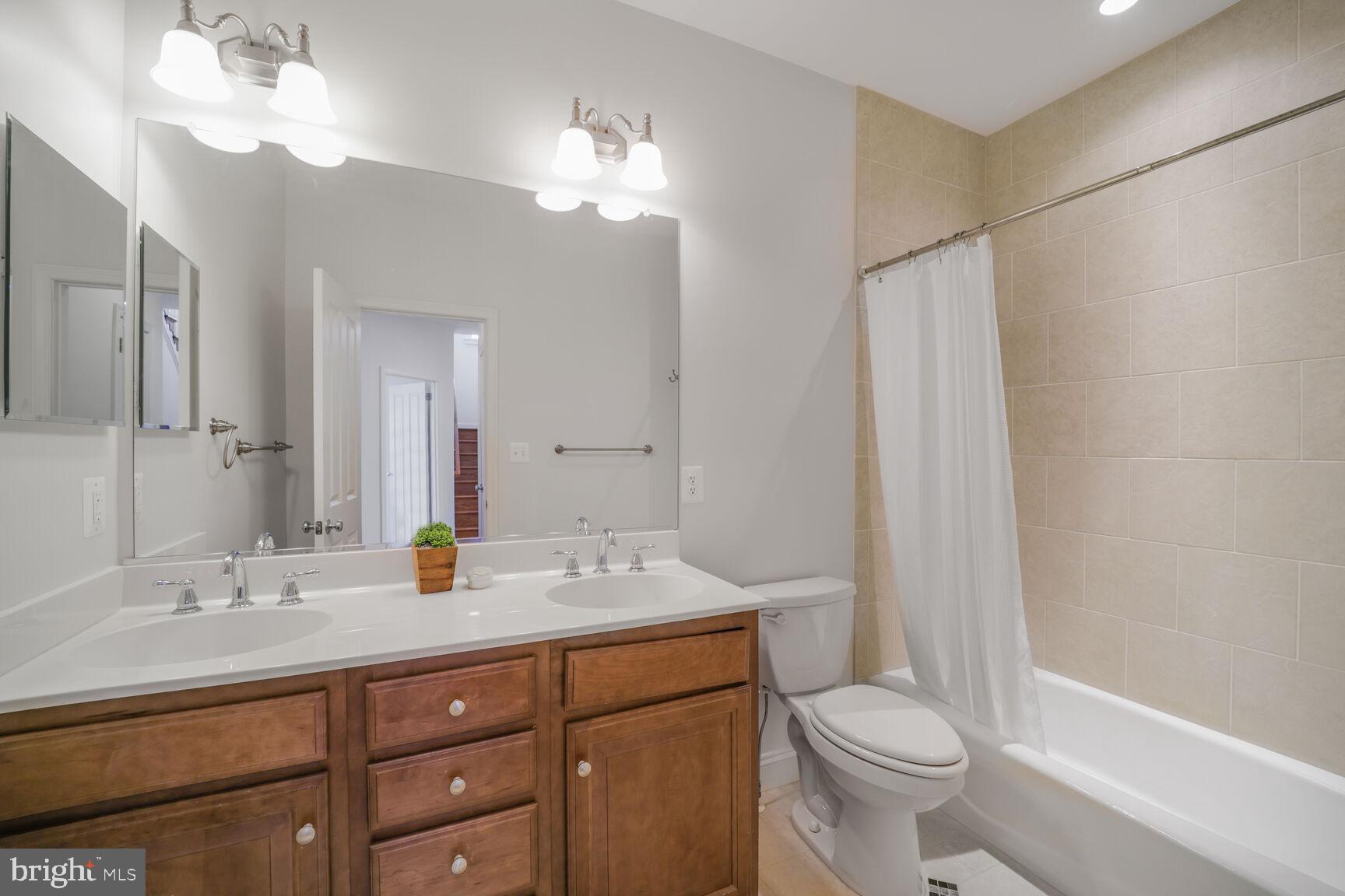 4814 25th Road North Arlington, VA 22207 - Photo 29 of 45 a bathroom with a sink a toilet a mirror a vanity and shower