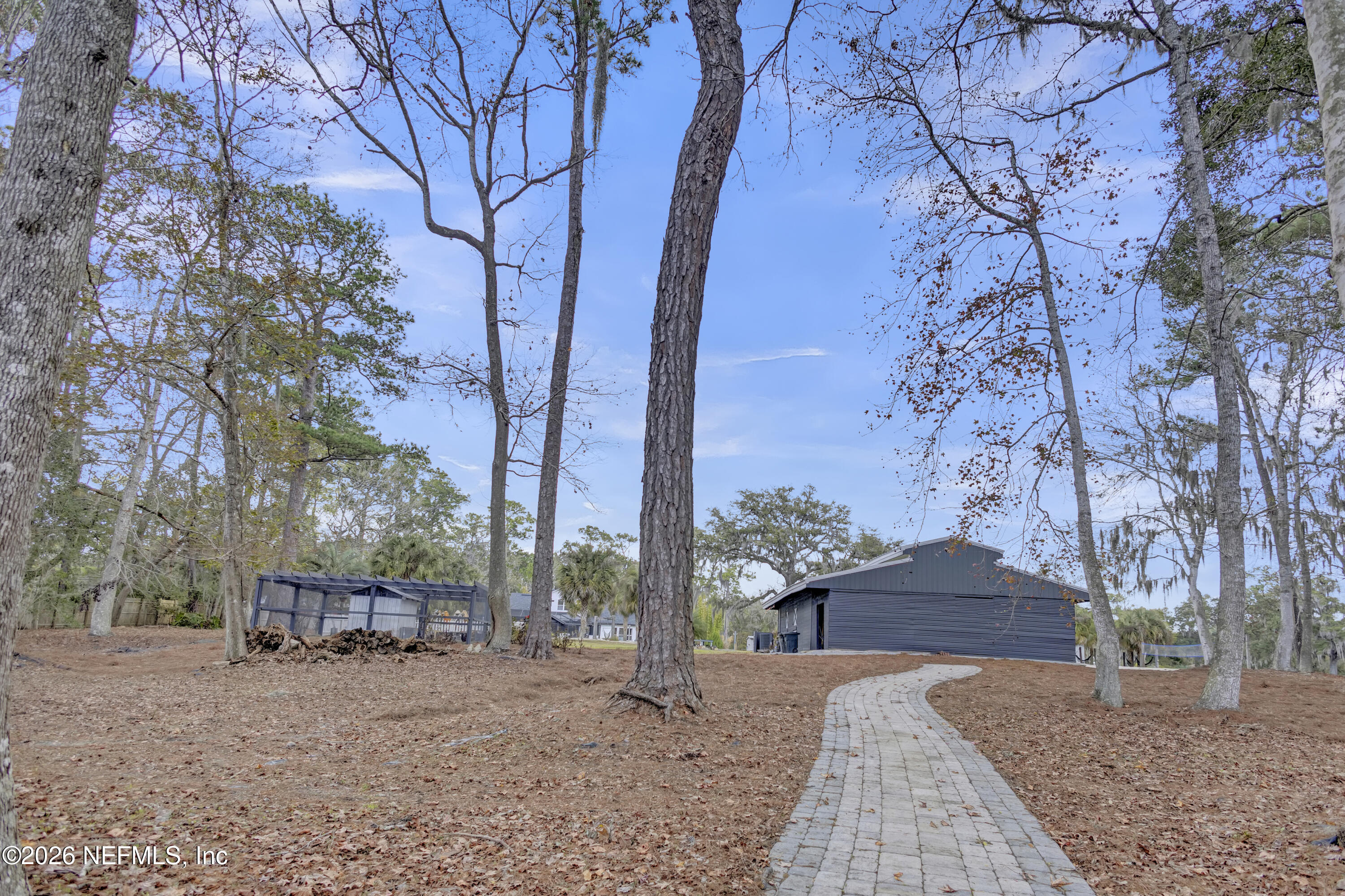 1387 Heath Road Green Cove Springs, FL 32043 - Photo 133 of 136 a backyard of a house with large trees and table and chairs