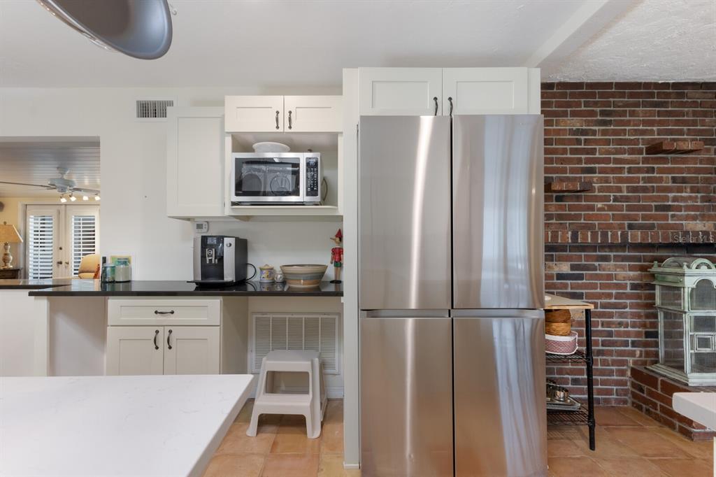 2723 59th Street Sarasota, FL 34243 - Photo 26 of 75 a kitchen with granite countertop a refrigerator and a stove top oven