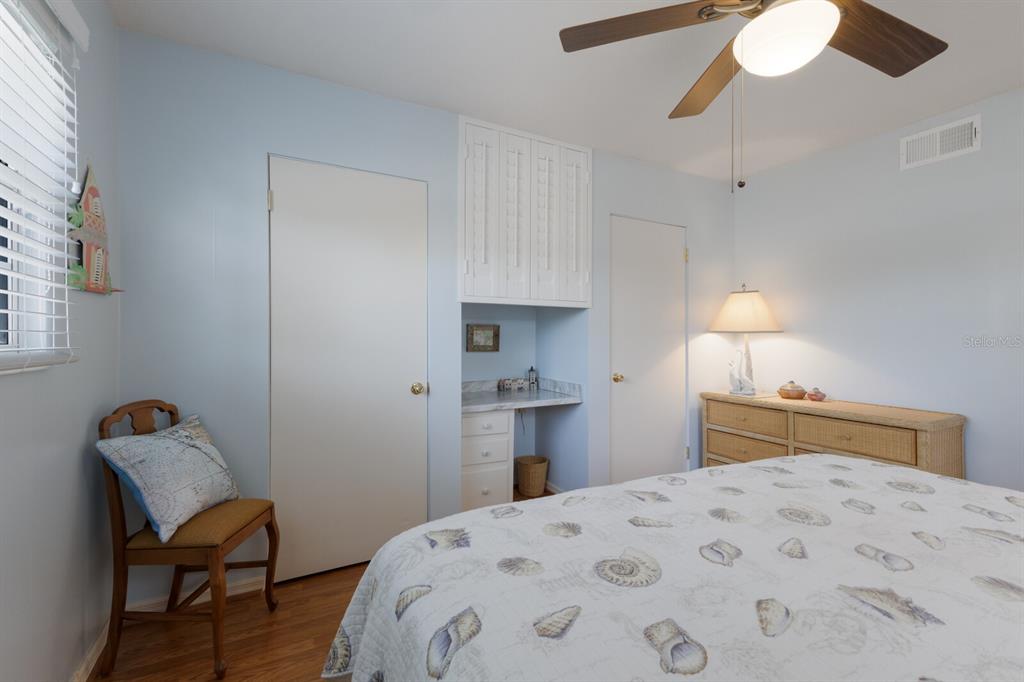 2723 59th Street Sarasota, FL 34243 - Photo 39 of 75 a bedroom with a bed and a lamp on dresser