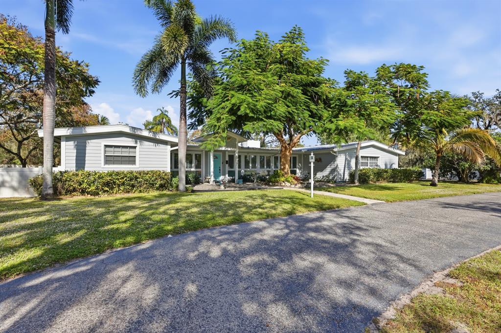 2723 59th Street Sarasota, FL 34243 - Photo 5 of 75 a view of a house with a big yard and palm trees