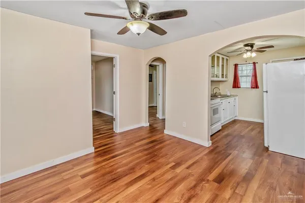 a view of a livingroom with wooden floor and a ceiling fan