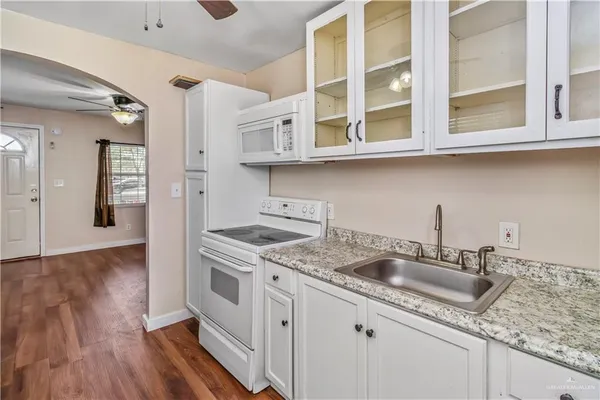 a kitchen with stainless steel appliances granite countertop a sink and dishwasher wooden cabinets with wooden floor