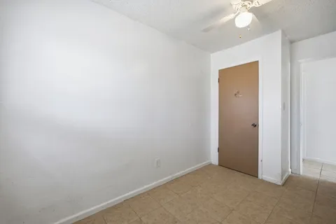 an empty room with a chandelier fan