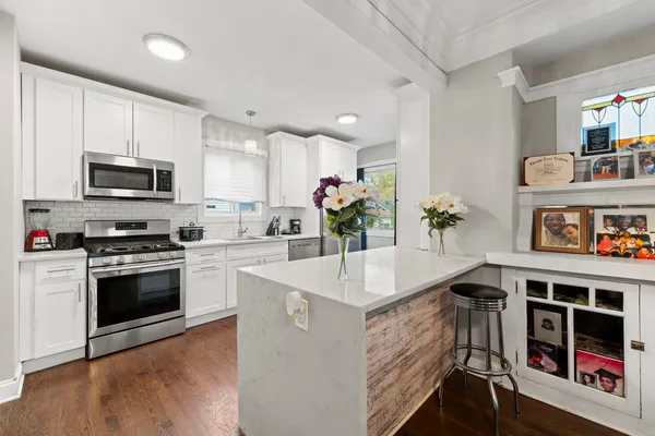 a kitchen with kitchen island white cabinets and appliances