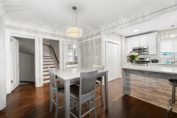 a kitchen with stainless steel appliances kitchen island granite countertop a table chairs and a refrigerator