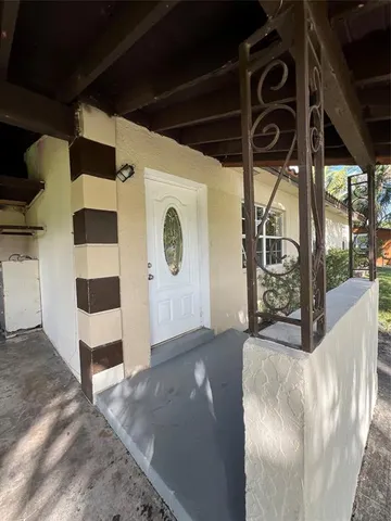 a view of a yard with plants and large trees