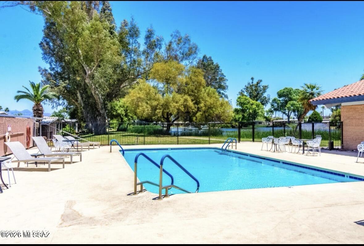 4550 North Flowing Wells Road, Unit 65 Tucson, AZ 85705 - Photo 46 of 50 a view of a swimming pool with an outdoor space and seating area
