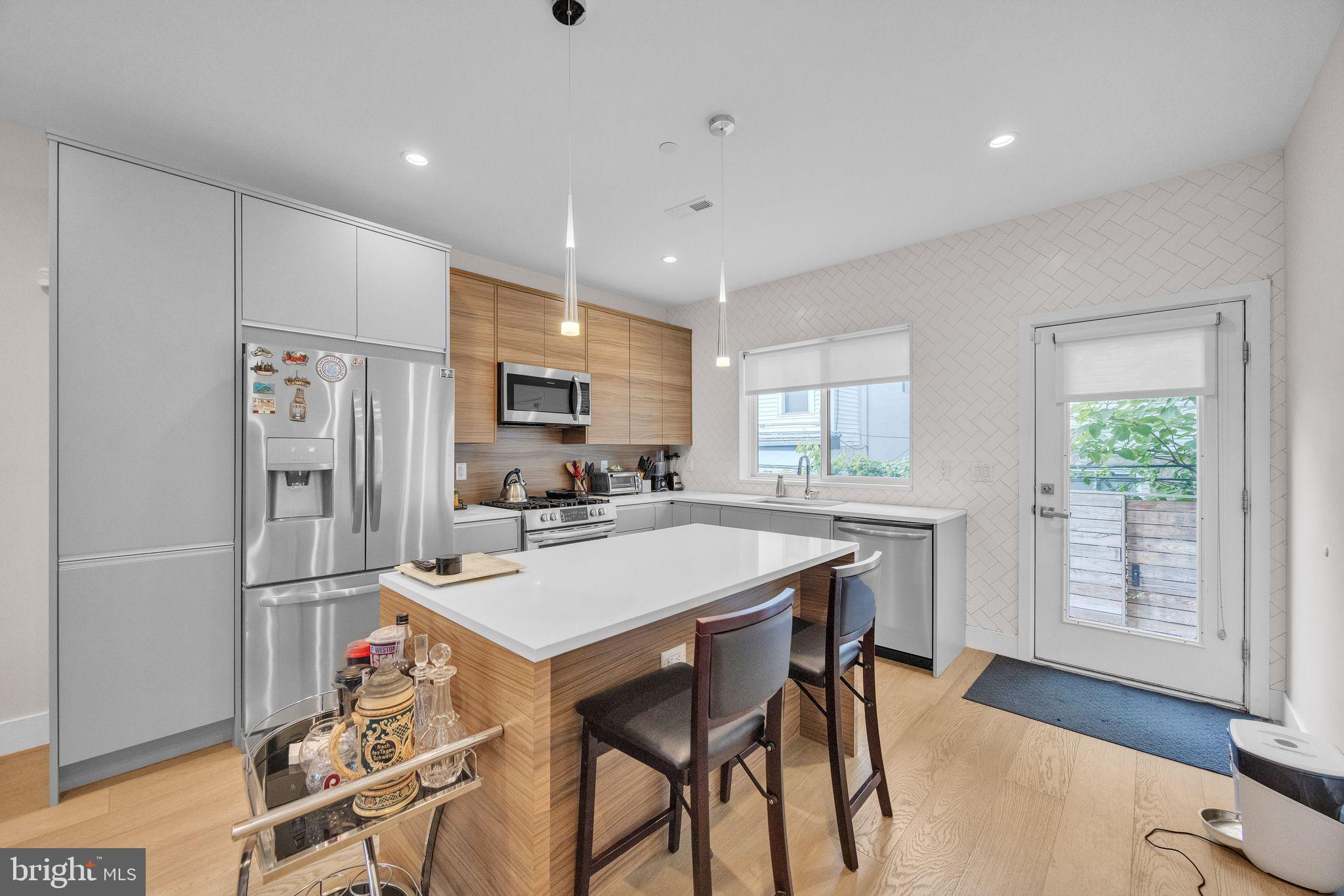 1752 North Bailey Street Philadelphia, PA 19121 - Photo 1 of 30 a kitchen with stainless steel appliances a dining table chairs refrigerator and sink