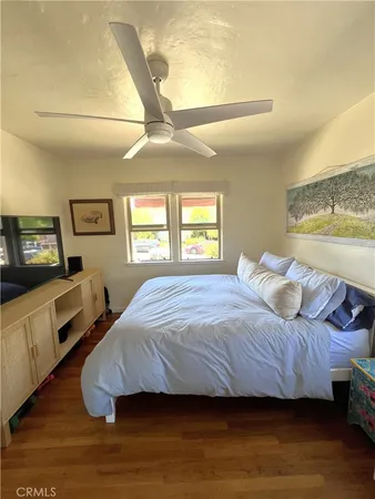 a bedroom with a bed and a flat tv screen on dresser