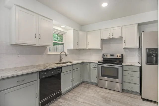 a kitchen with granite countertop cabinets stainless steel appliances and a sink