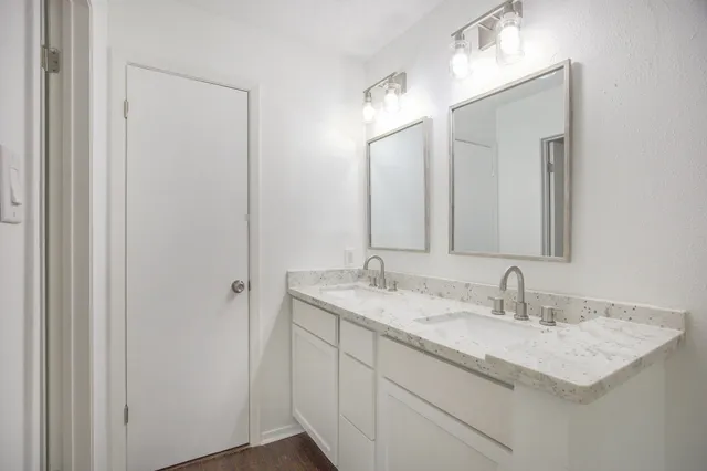 a bathroom with a granite countertop sink and a mirror