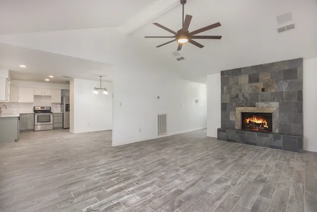 a view of an empty room with a fireplace and a window