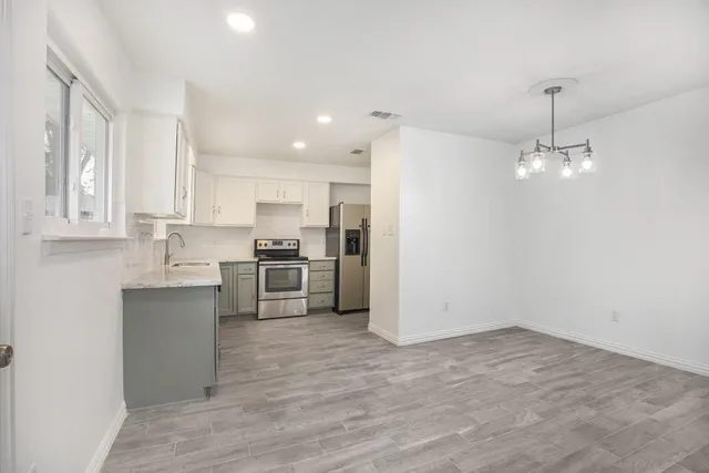 a kitchen with stainless steel appliances a refrigerator sink and cabinets