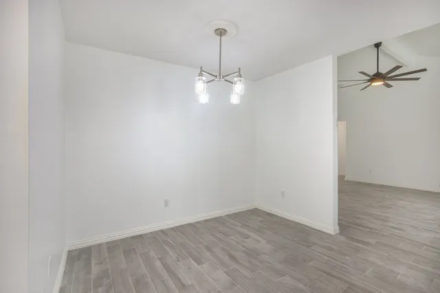 a view of a room with wooden floor and a ceiling fan