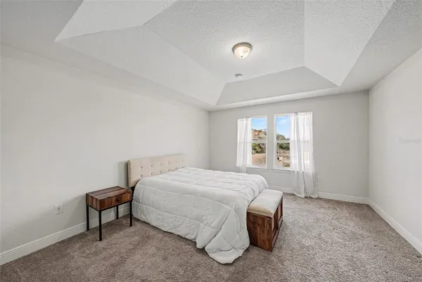 a spacious bedroom with a bed and a window