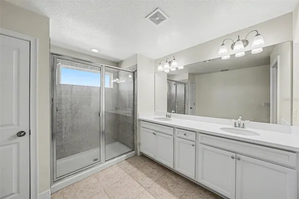 a bathroom with a double vanity sink mirror and shower