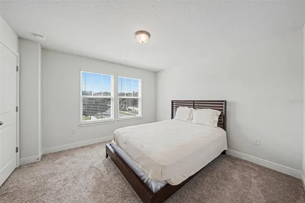 a large bed sitting in a bedroom next to a window