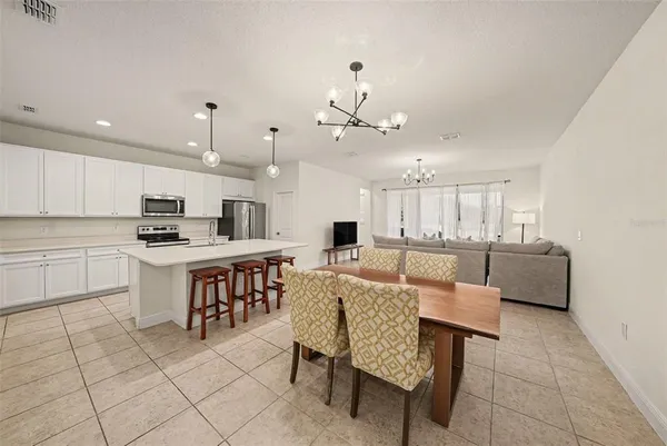 a kitchen with kitchen island stainless steel appliances a table and chairs in it