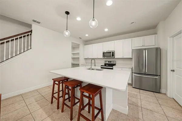 a kitchen with refrigerator cabinets and wooden floor