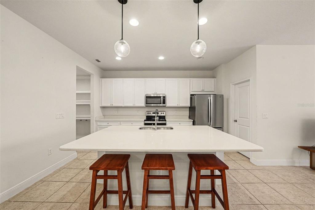 10210 Newel Valley Loop Riverview, FL 33569 - Photo 5 of 30 a kitchen with refrigerator a sink and chairs