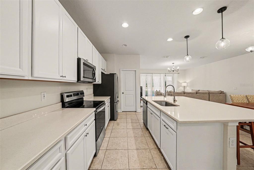 10210 Newel Valley Loop Riverview, FL 33569 - Photo 6 of 30 a large white kitchen with stainless steel appliances granite countertop a sink a stove and a refrigerator