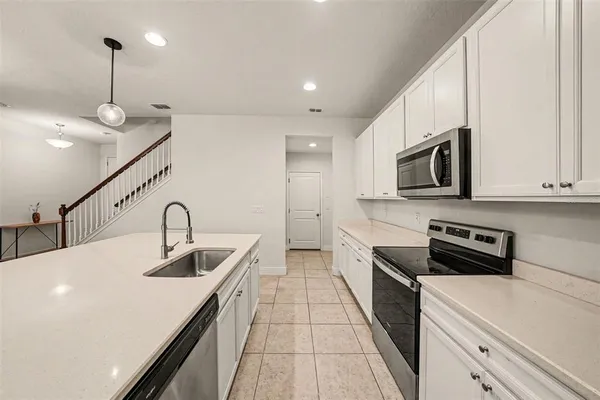 a kitchen with stainless steel appliances kitchen island a white stove top oven and sink