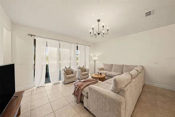 a living room with furniture and a chandelier