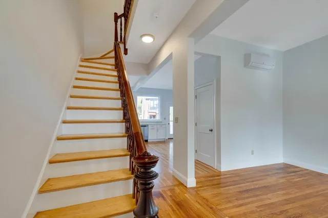 a view of entryway and hall with wooden floor