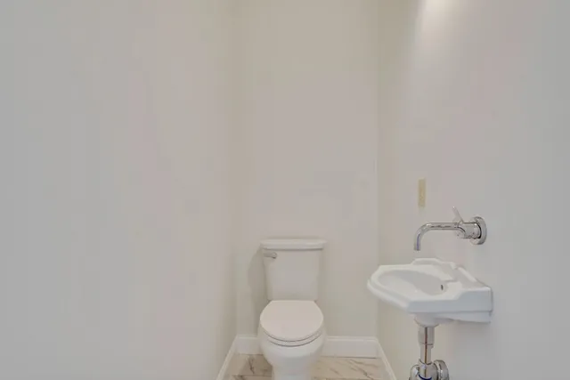 a bathroom with a toilet a sink and mirror