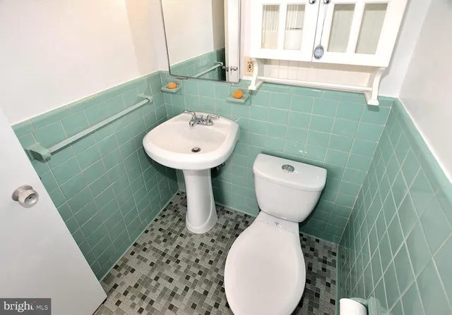 a bathroom with a toilet sink and mirror