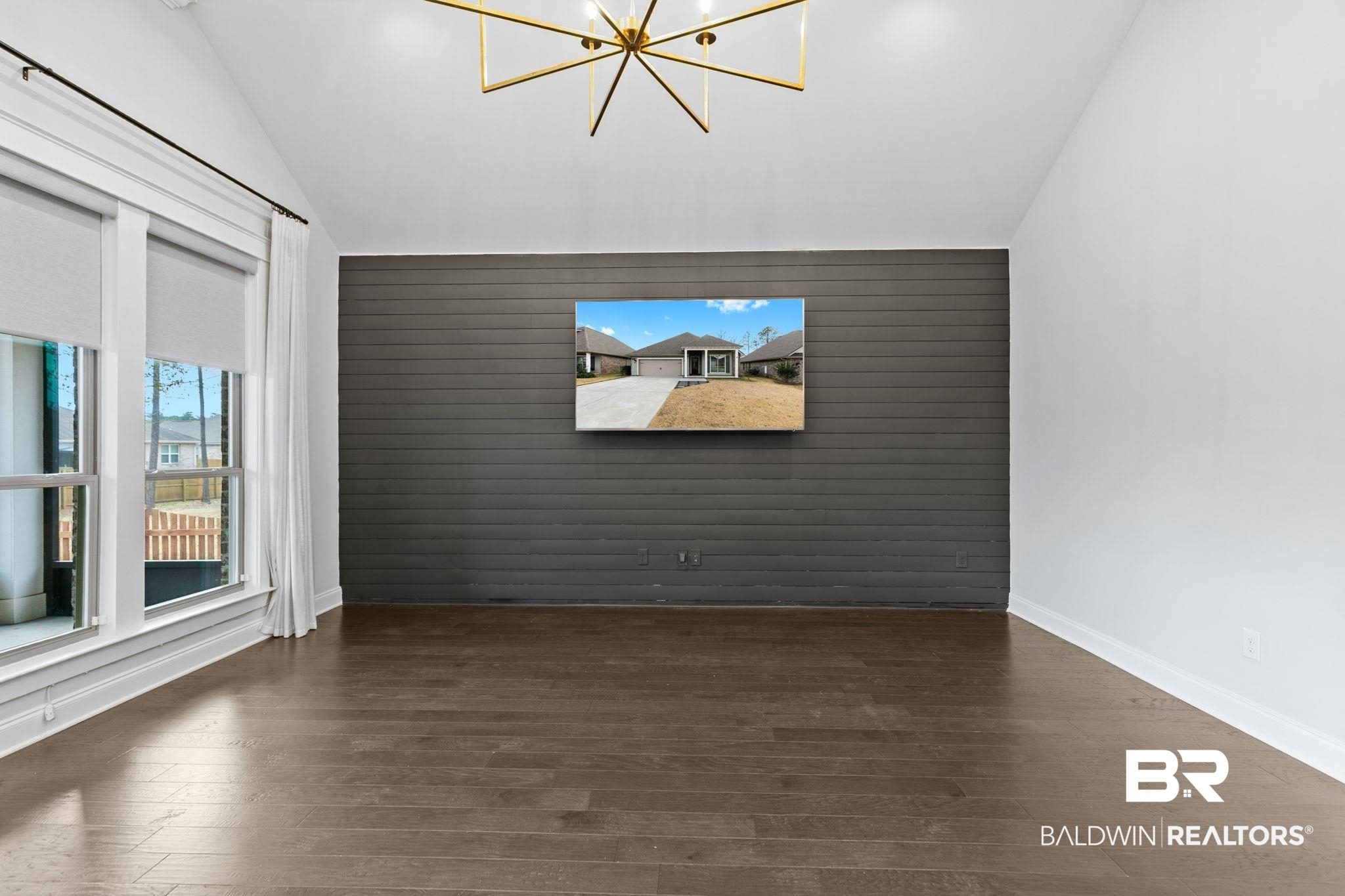 31654 Canopy Loop Daphne, AL 36527 - Photo 12 of 64 Unfurnished room featuring wood walls, dark wood finished floors, a chandelier, an accent wall, and vaulted ceiling