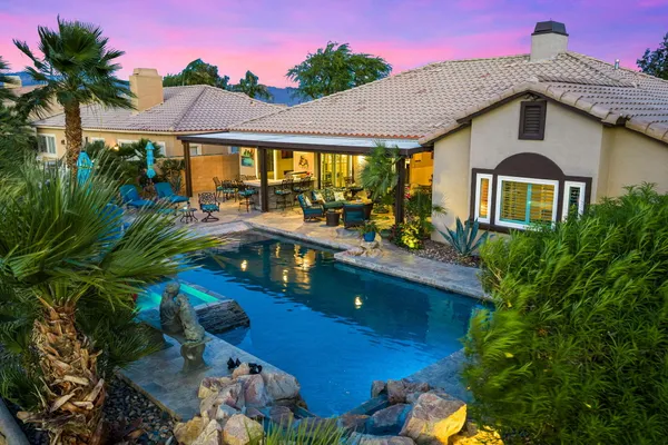 a view of a swimming pool with a patio and a yard