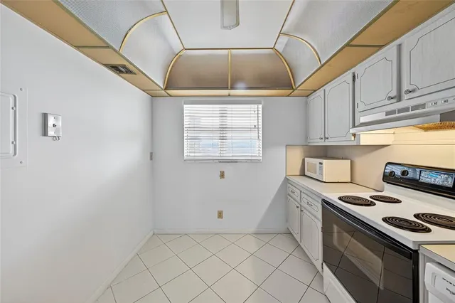 a kitchen with a stove a sink and cabinets