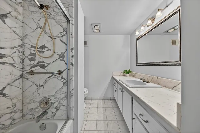 a spacious bathroom with a double vanity sink a toilet and a mirror