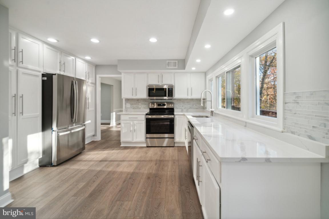 517 Holly Road Fort Washington, MD 20744 - Photo 12 of 40 a large kitchen with stainless steel appliances granite countertop a stove a sink and a refrigerator