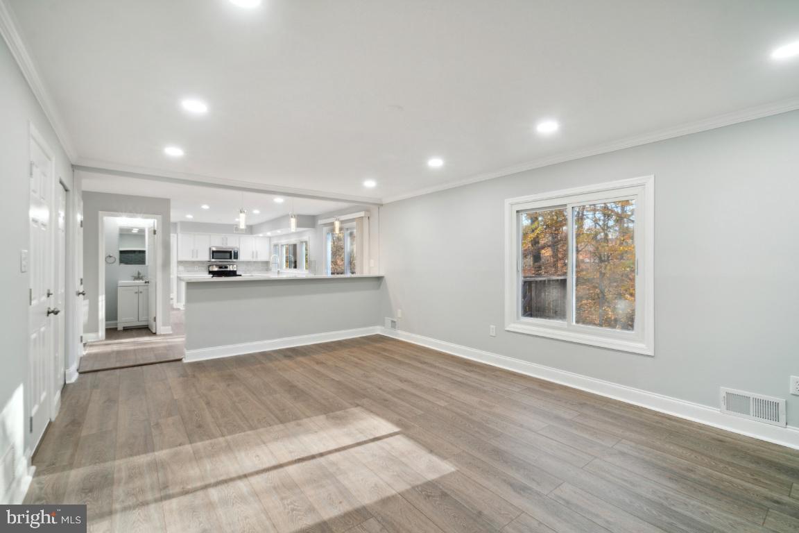 517 Holly Road Fort Washington, MD 20744 - Photo 14 of 40 a view of an empty room with wooden floor and a kitchen