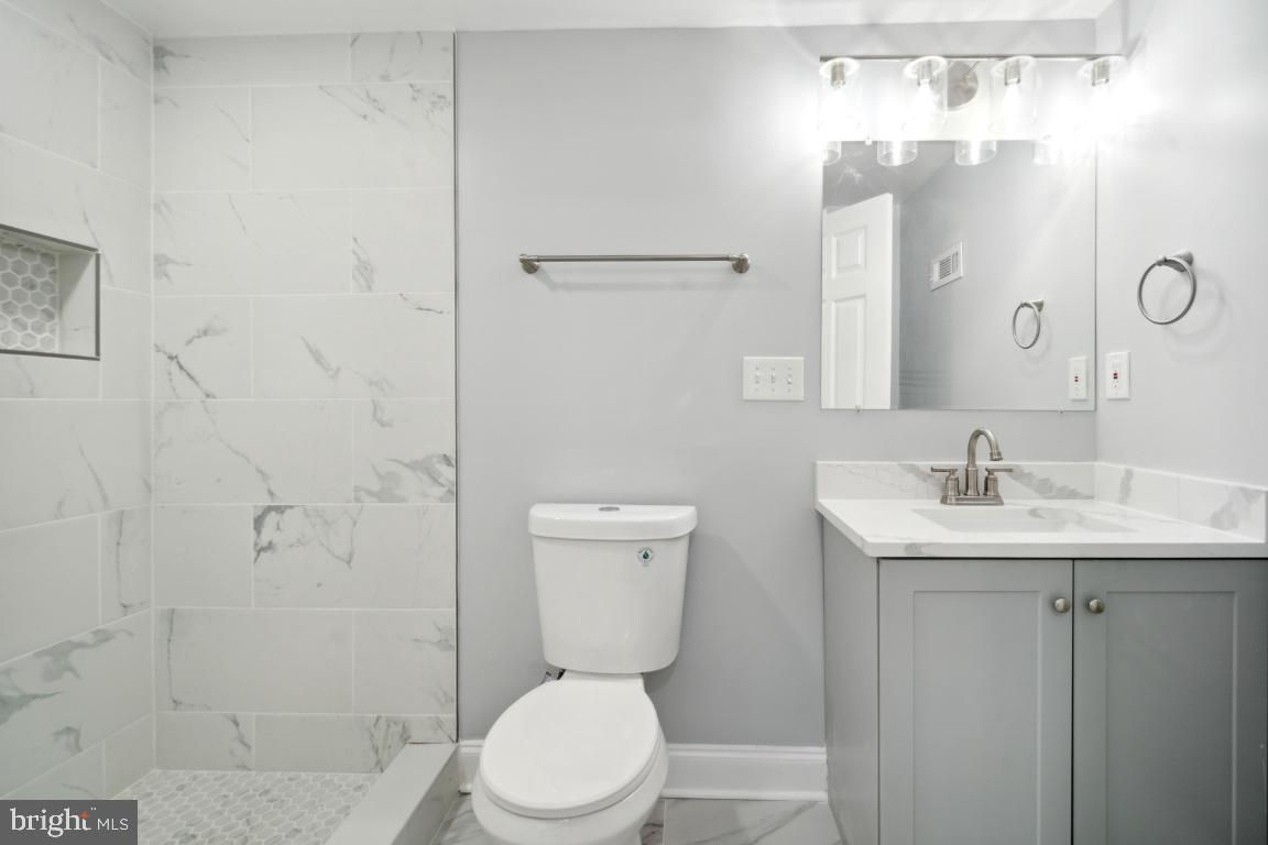 517 Holly Road Fort Washington, MD 20744 - Photo 26 of 40 a bathroom with a toilet a sink a mirror and shower