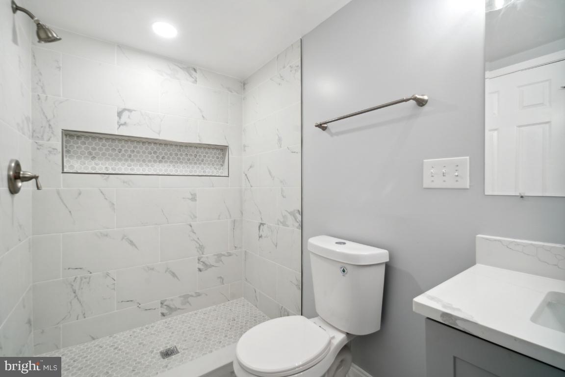 517 Holly Road Fort Washington, MD 20744 - Photo 27 of 40 a white toilet sitting next to a bathroom sink and a shower