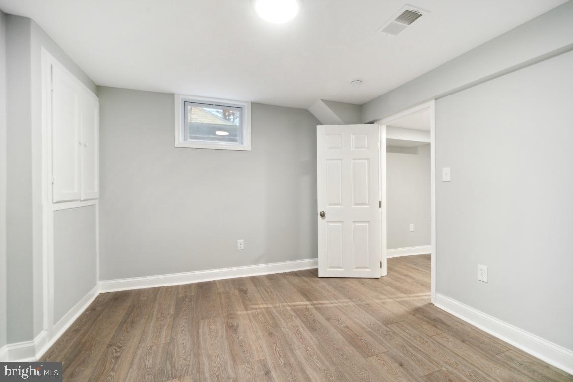 517 Holly Road Fort Washington, MD 20744 - Photo 31 of 40 an empty room with wooden floor and cabinets