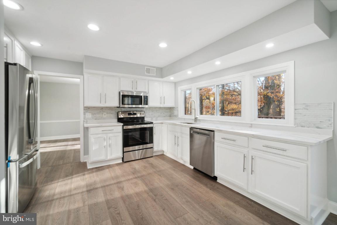 517 Holly Road Fort Washington, MD 20744 - Photo 33 of 40 a kitchen with granite countertop white cabinets and stainless steel appliances