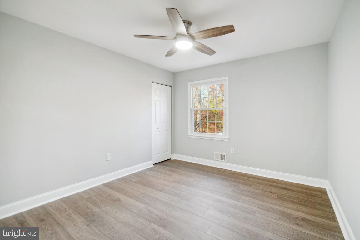 517 Holly Road Fort Washington, MD 20744 - Photo 5 of 40 an empty room with wooden floor ceiling fan and windows