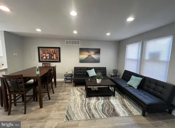 a living room with furniture and a glass table with wooden floor
